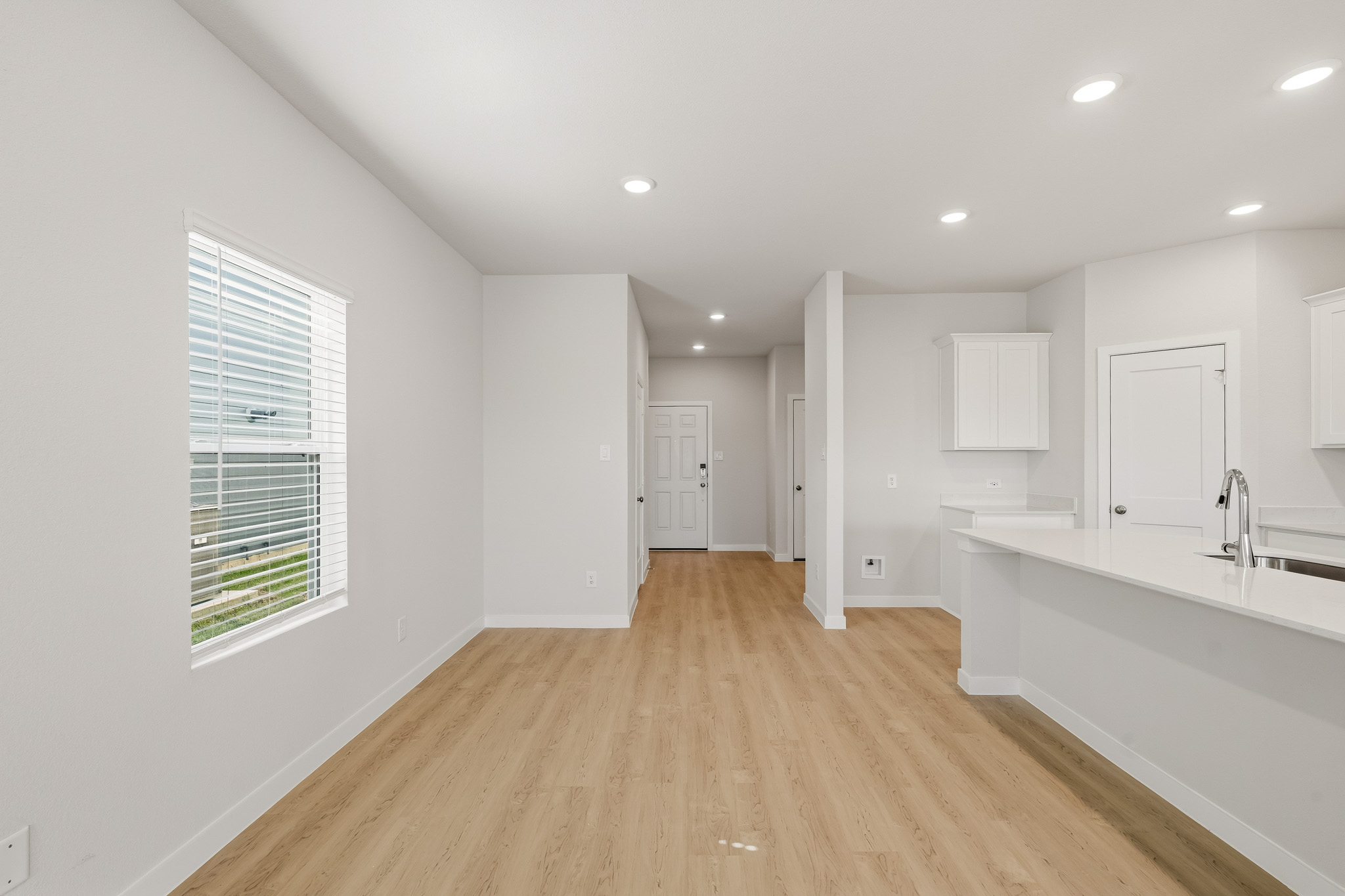 A white bathroom with a wood floor.