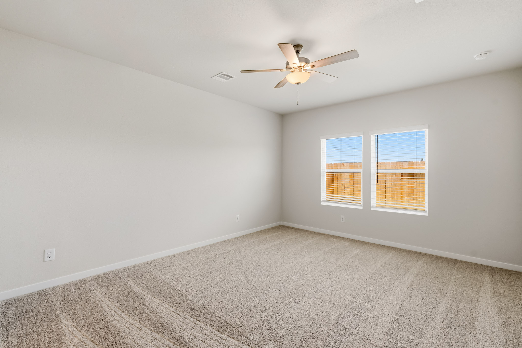 A room with a ceiling fan and a window.