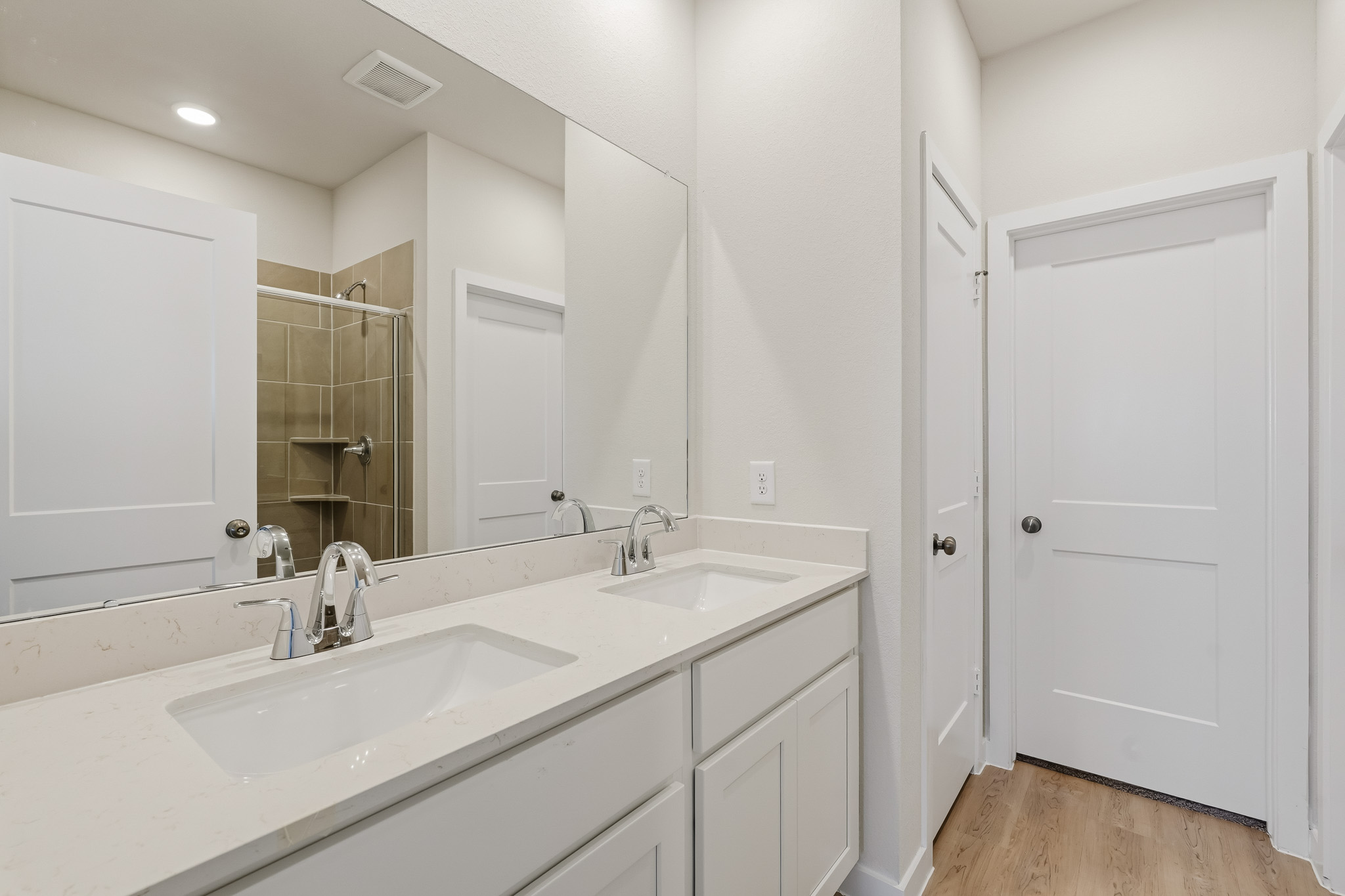A bathroom with white cabinets.