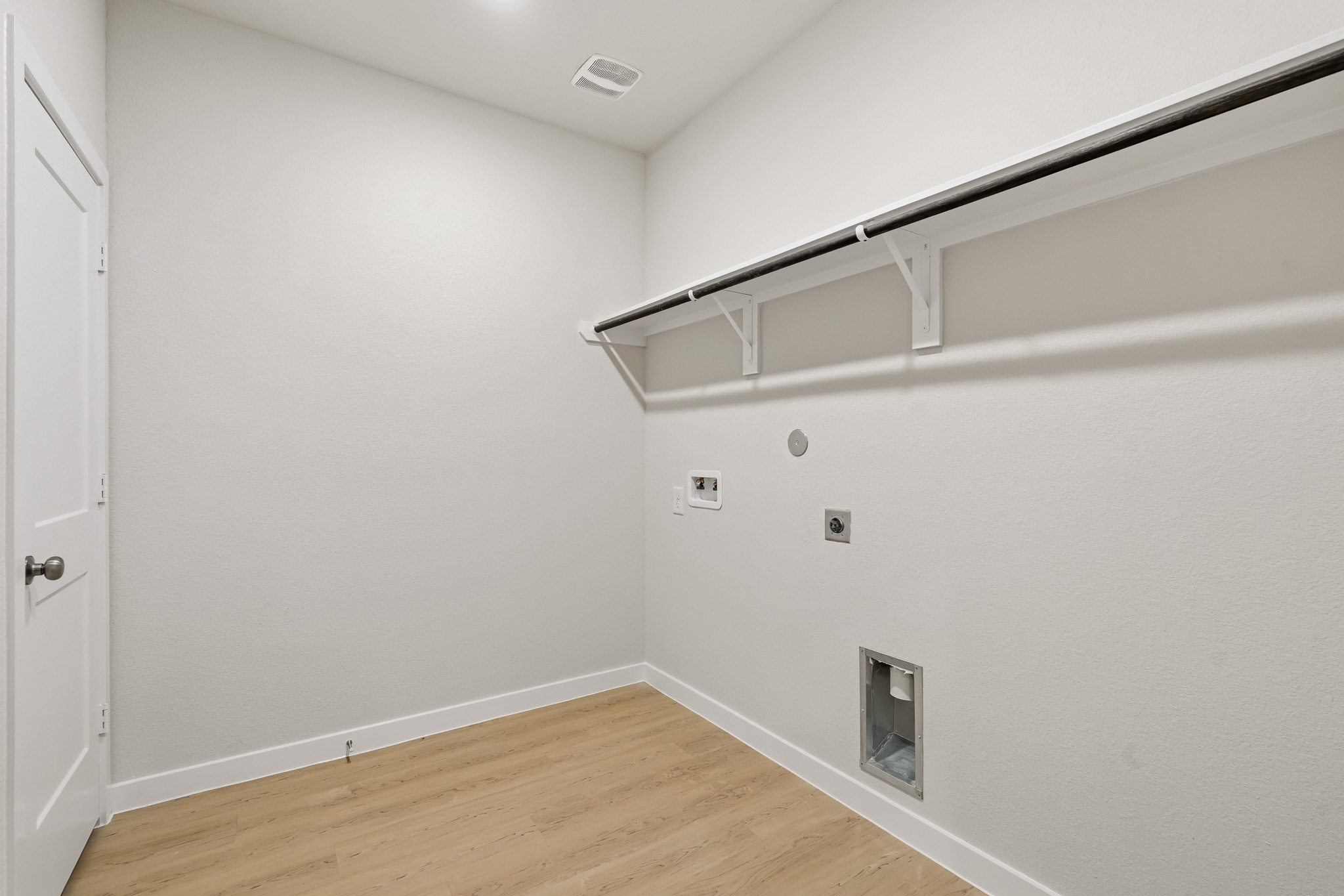 A white room with a wood floor.