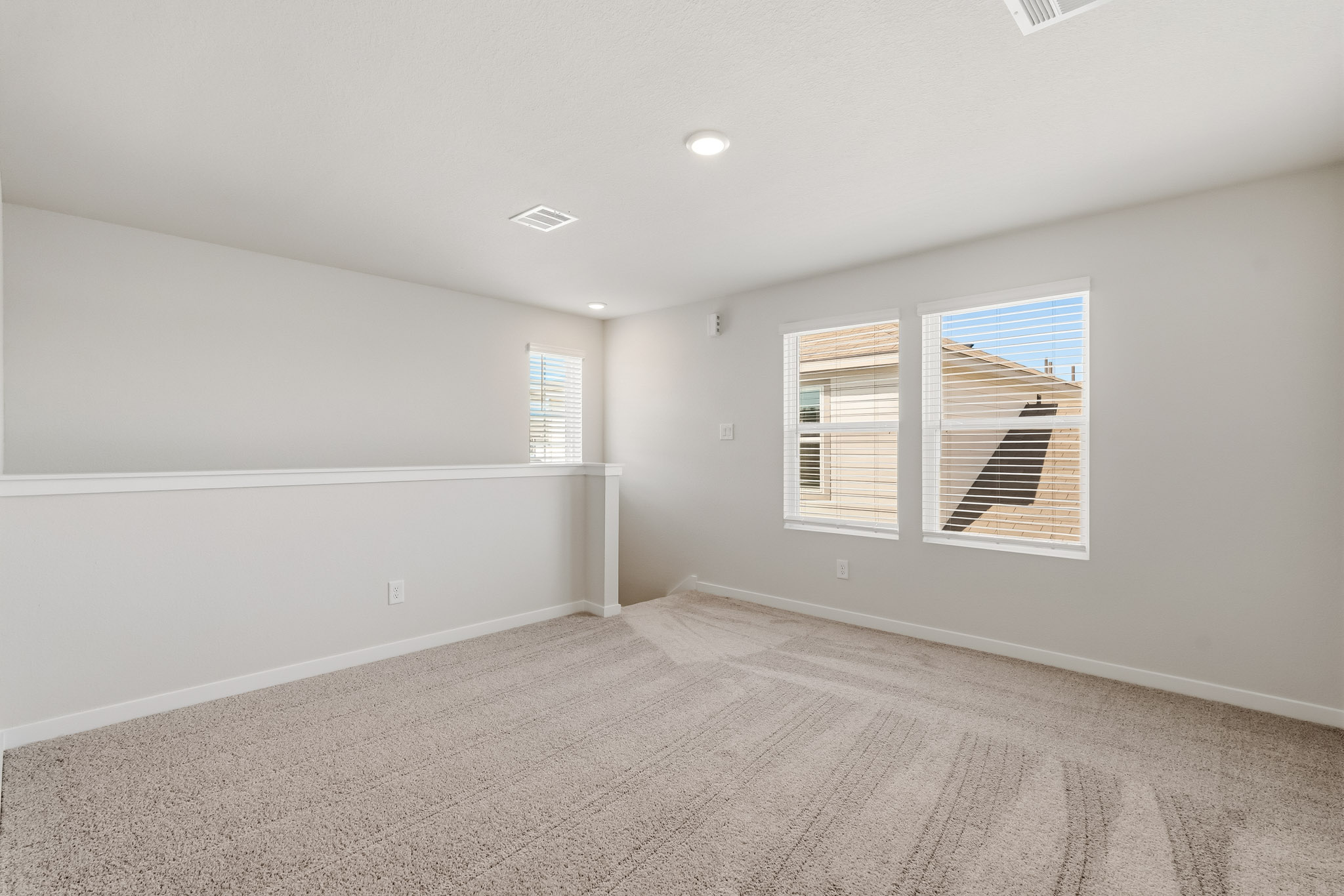 A room with a window and a white wall.