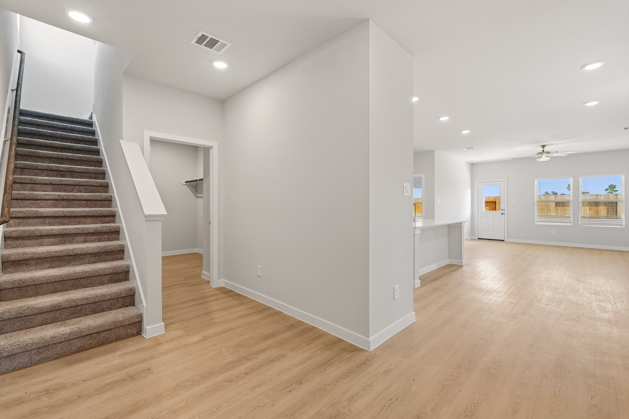 A large empty room with a staircase.