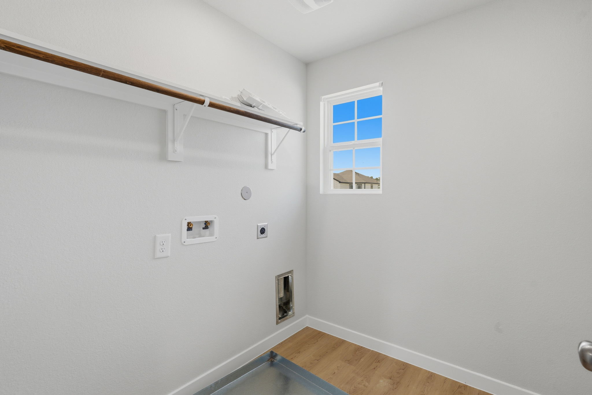 A room with a window and a wood floor.