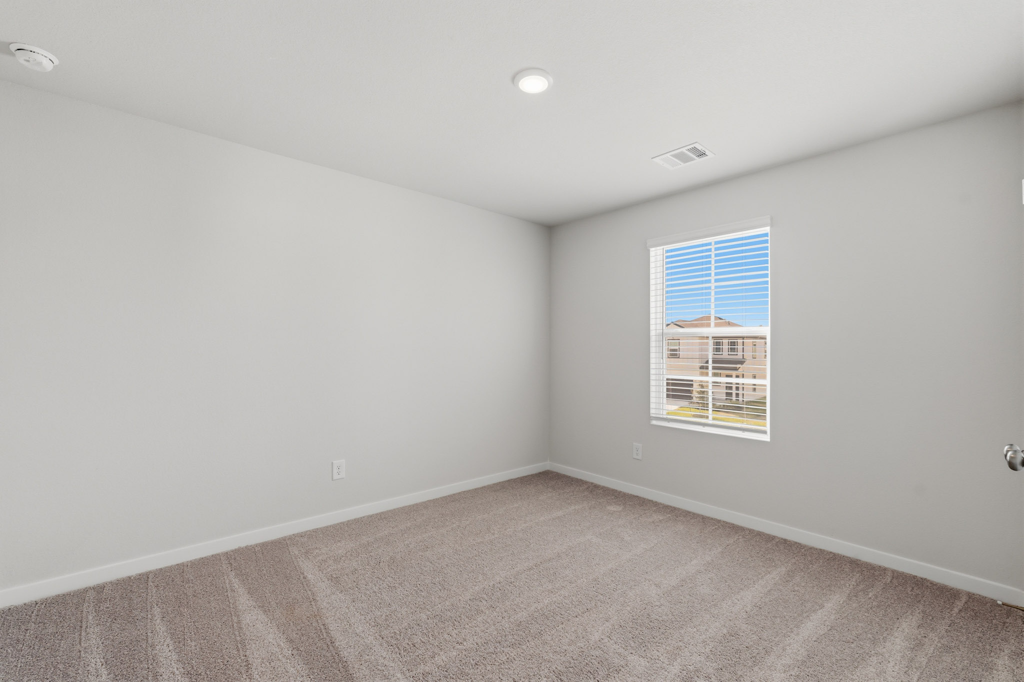 A room with a window and a carpet.