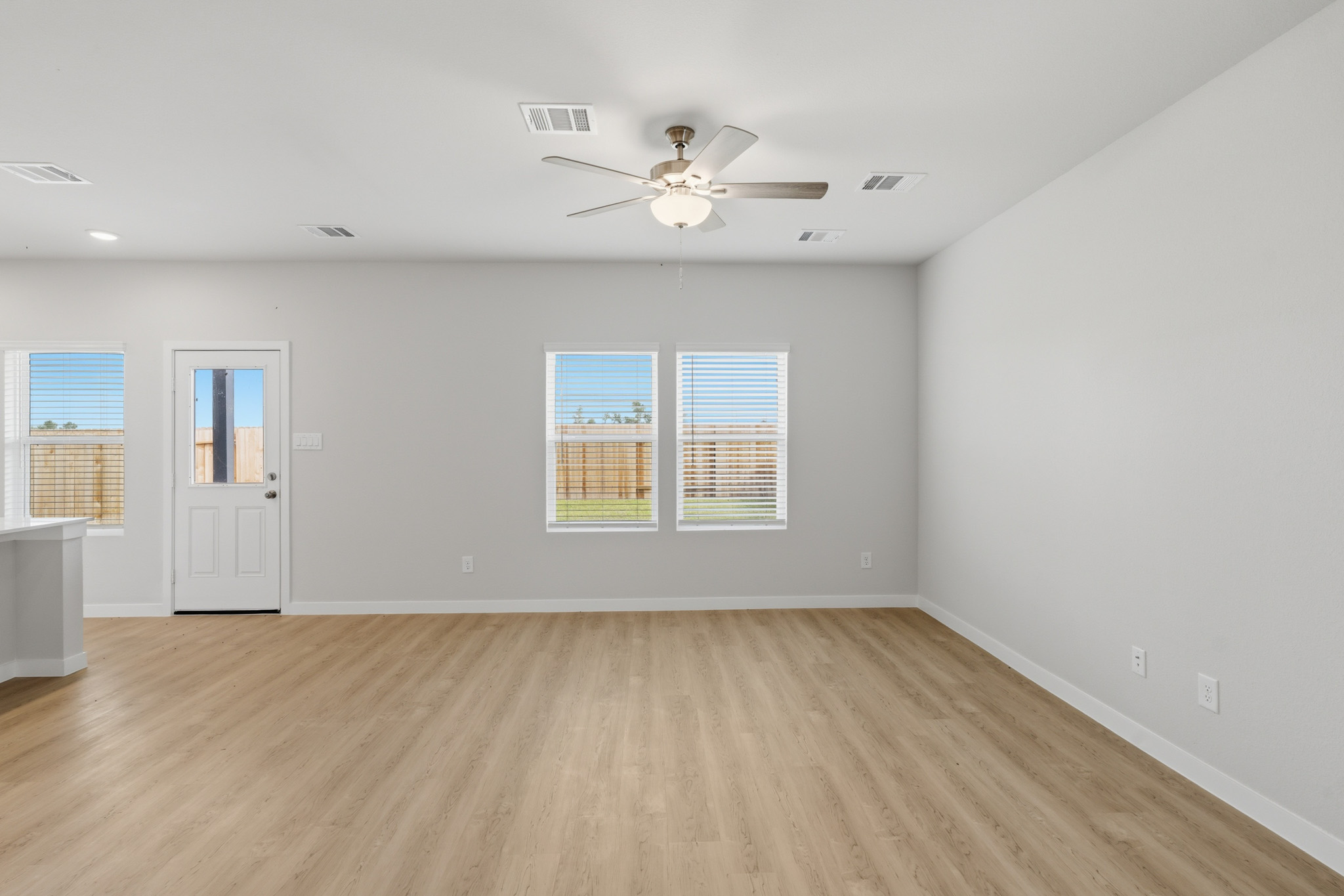 A room with a wood floor and a ceiling fan.