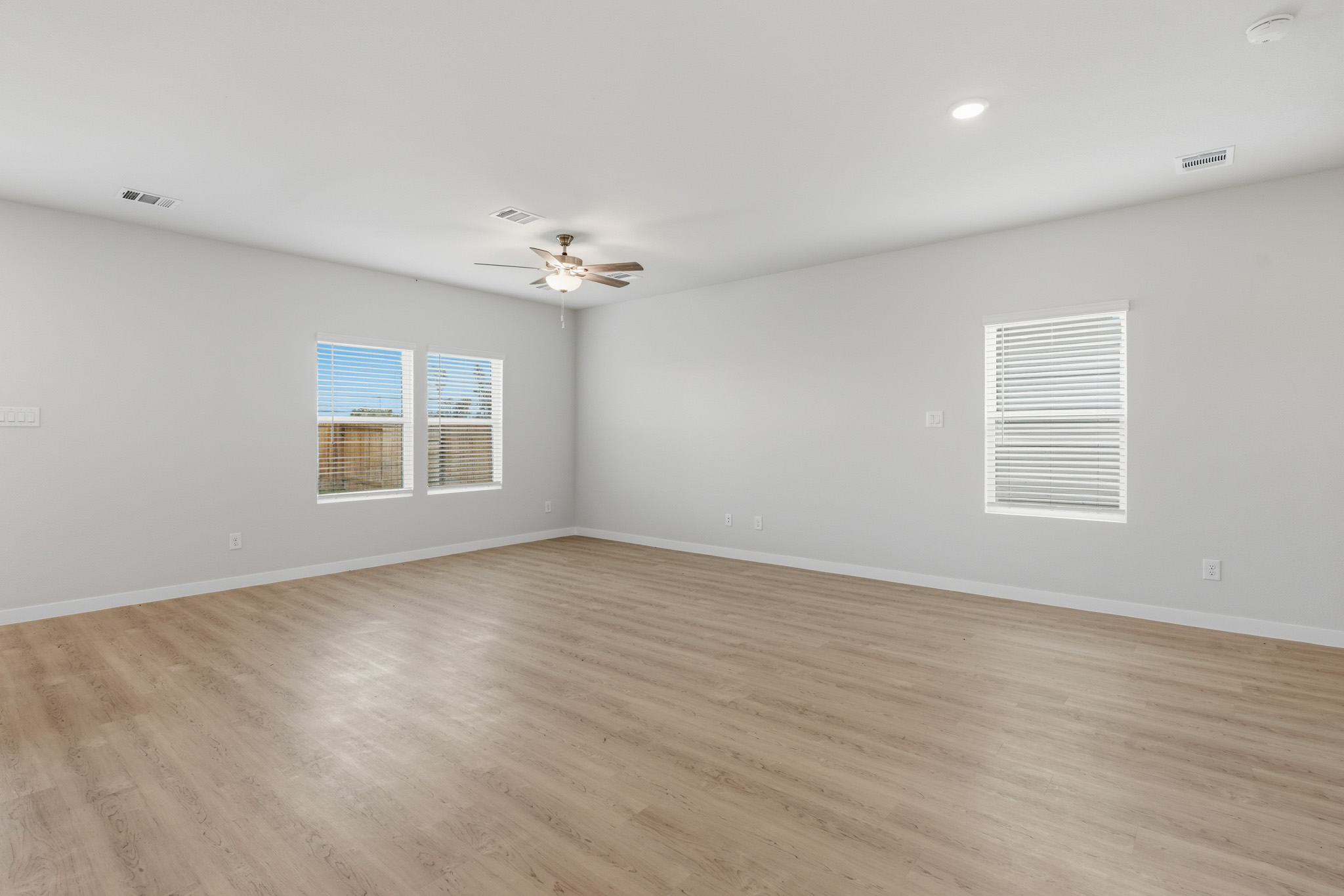 A room with a wood floor and a ceiling fan.
