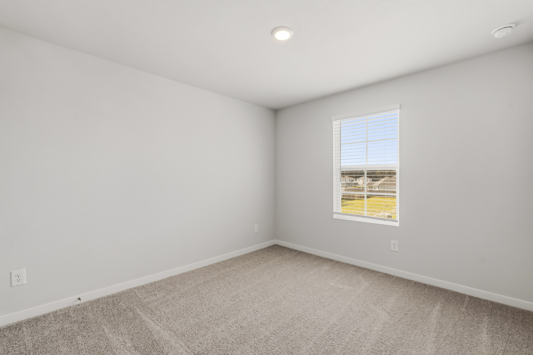 A room with a window and a carpet.