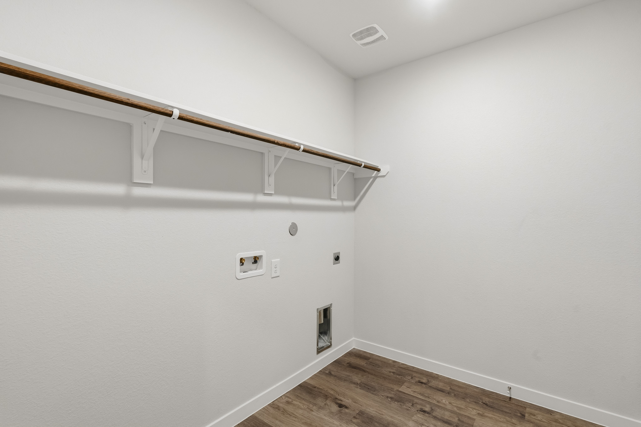 A white room with a wood floor.