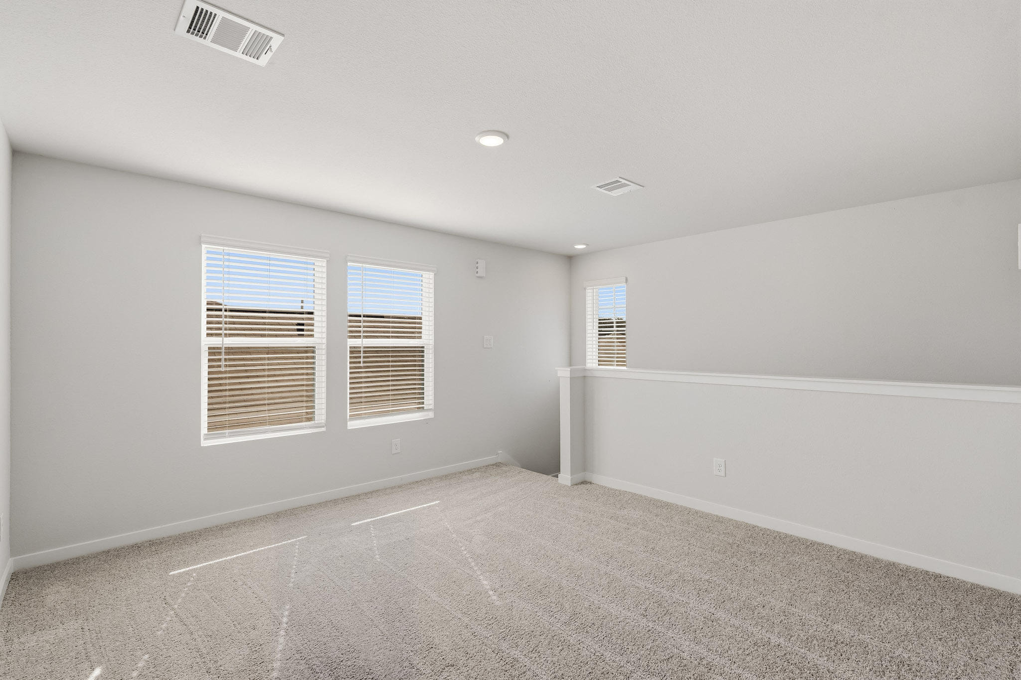 A room with a white wall and windows.