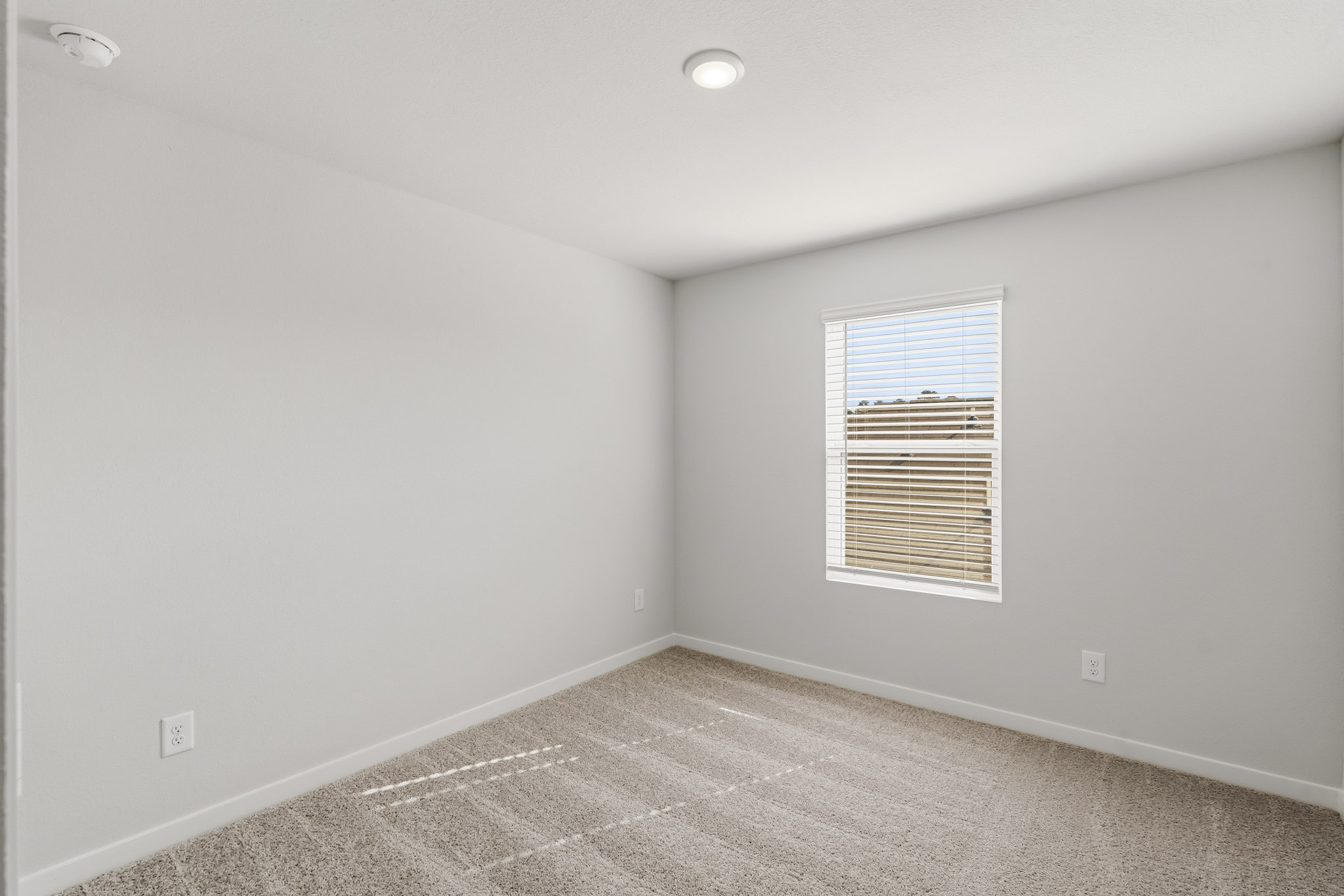 A room with a window and a carpet.