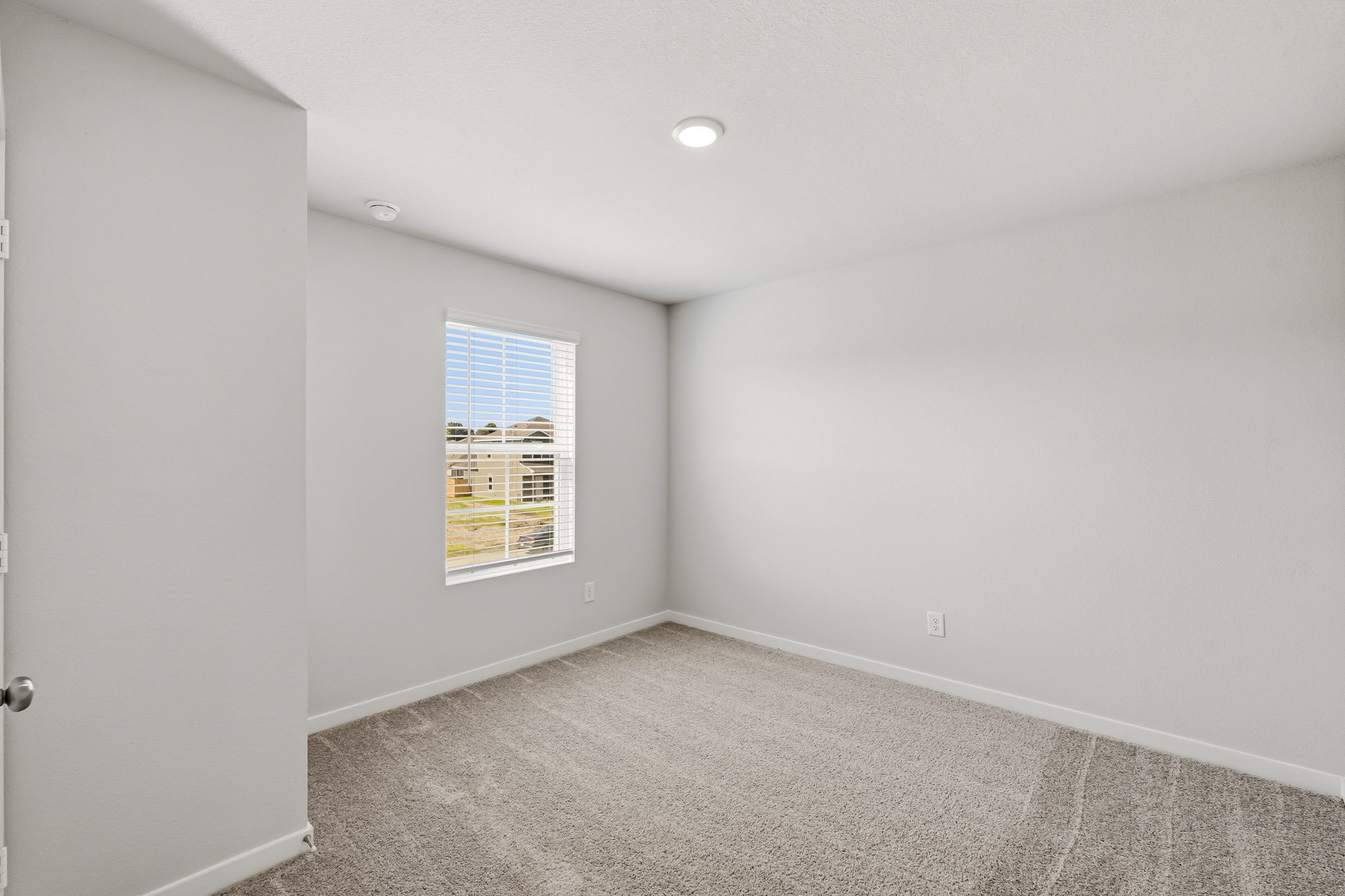 A room with a window and carpet.