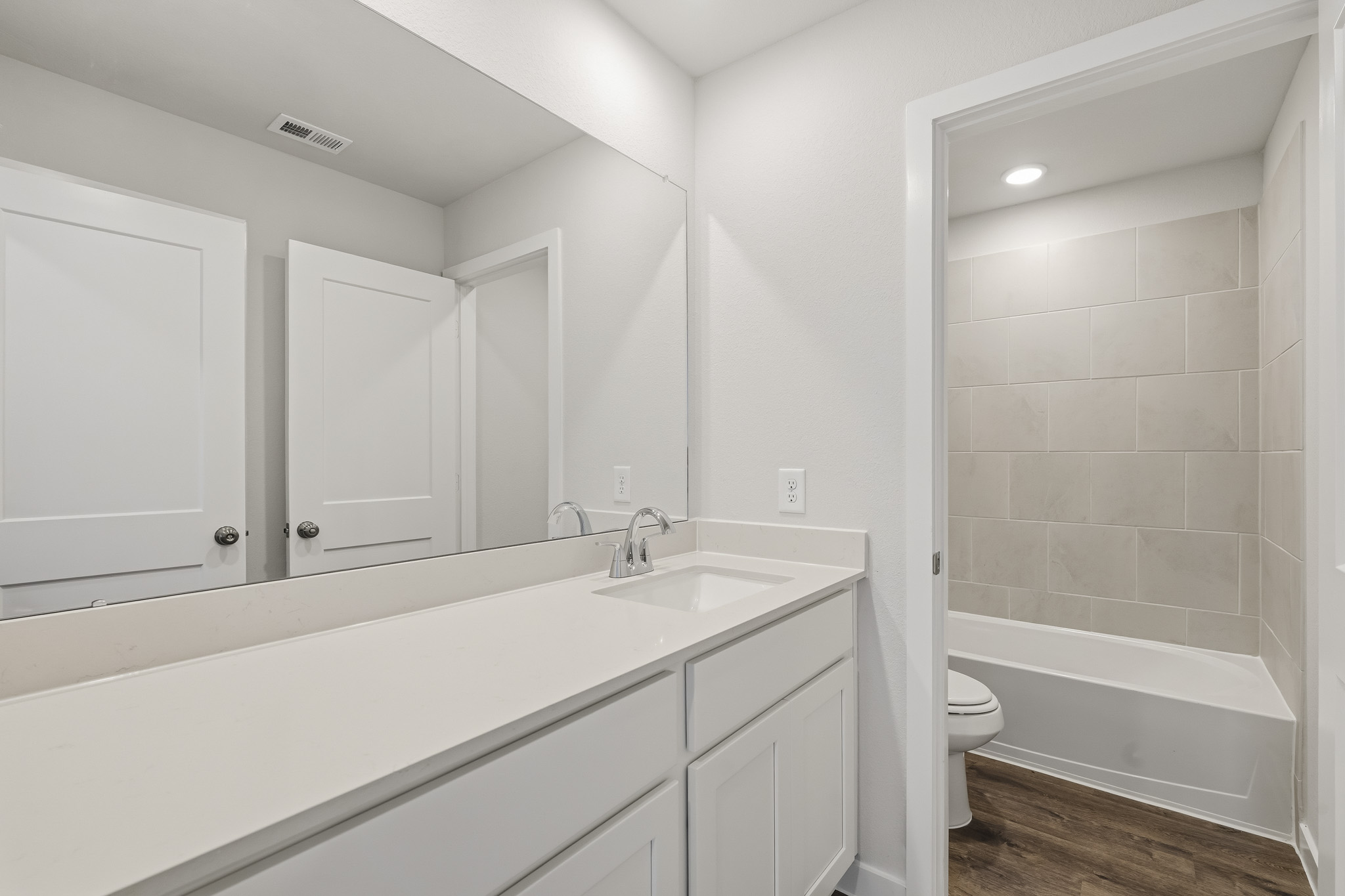 A bathroom with white cabinets.
