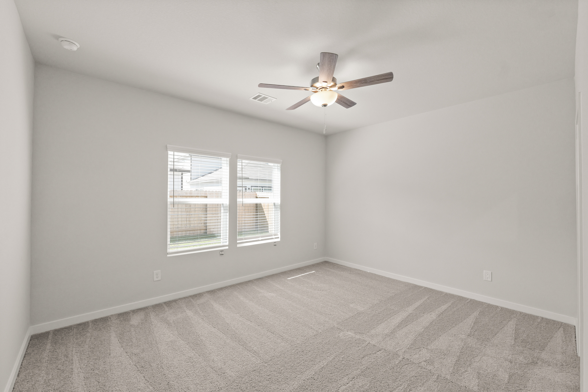 A room with a ceiling fan and a window.