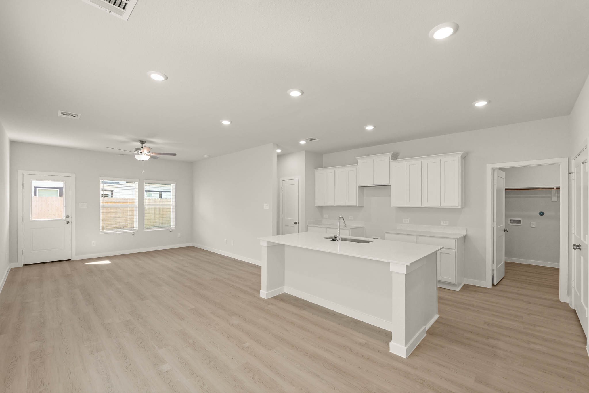 A large empty room with white cabinets.