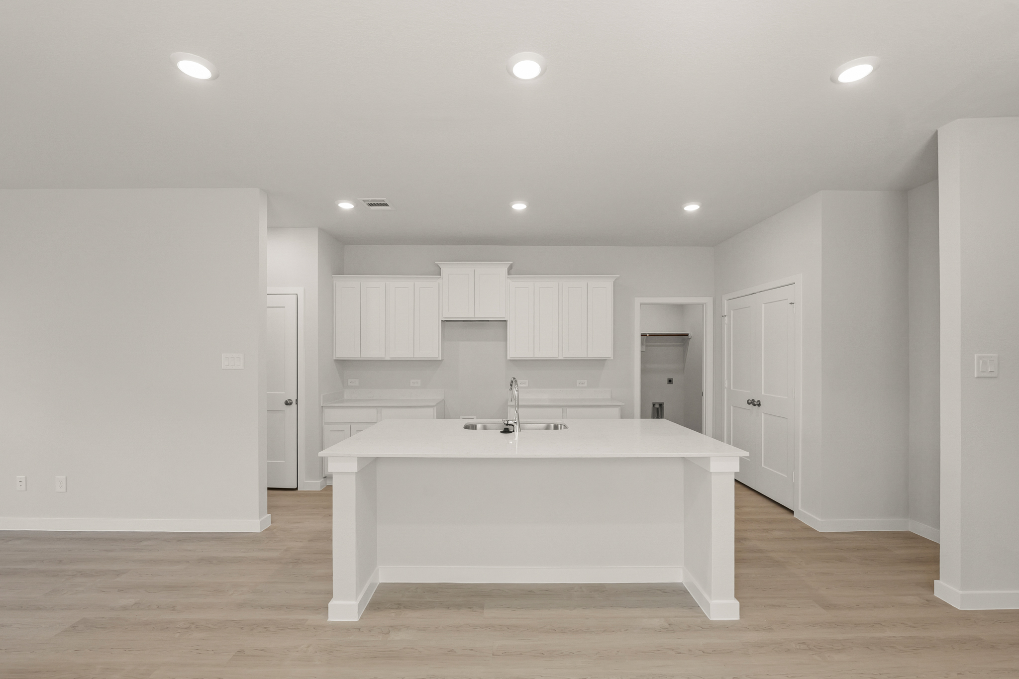 A large white kitchen with white cabinets.