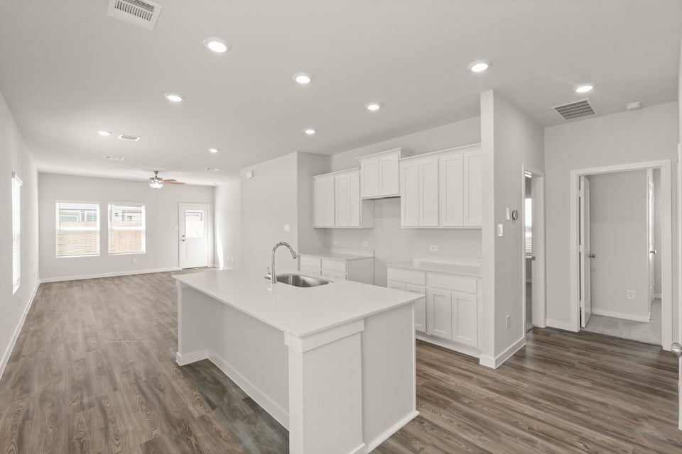 A kitchen with white cabinets.