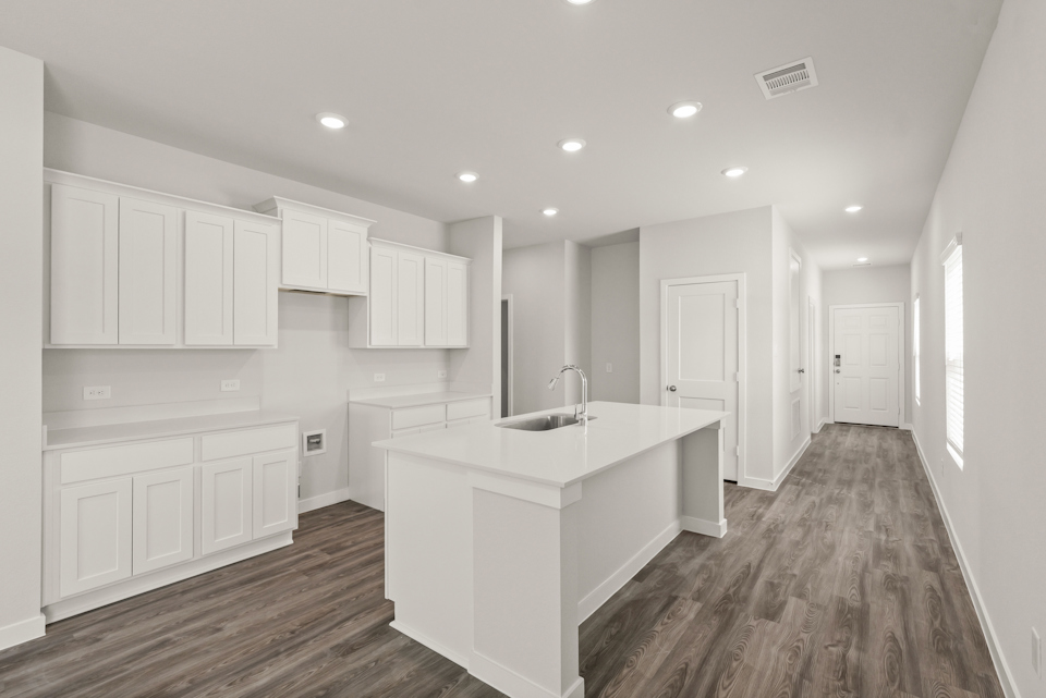 A kitchen with white cabinets.