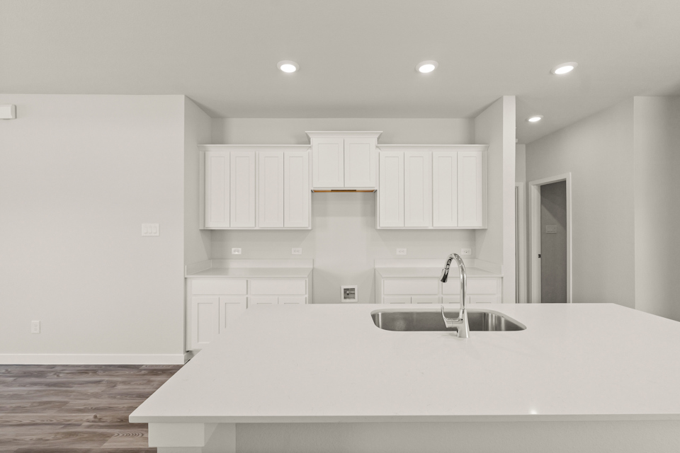 A kitchen with white cabinets.