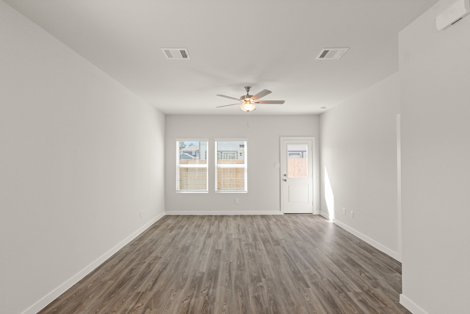 A room with a wood floor and a ceiling fan.