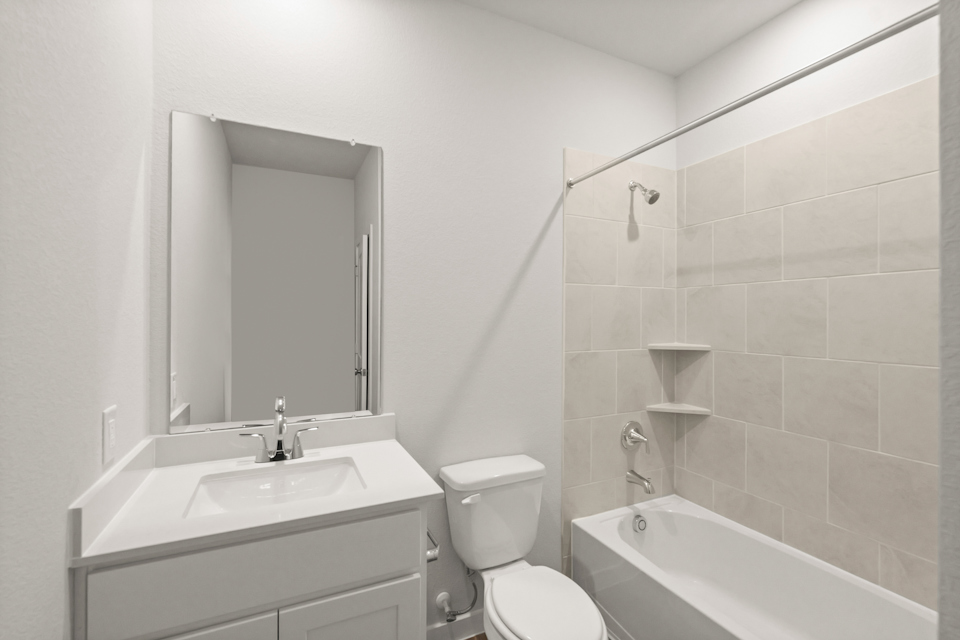 A bathroom with a tub sink and toilet.