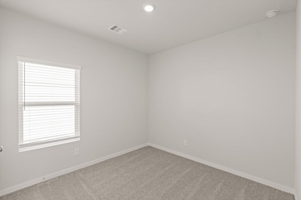 A room with a window and a carpet.