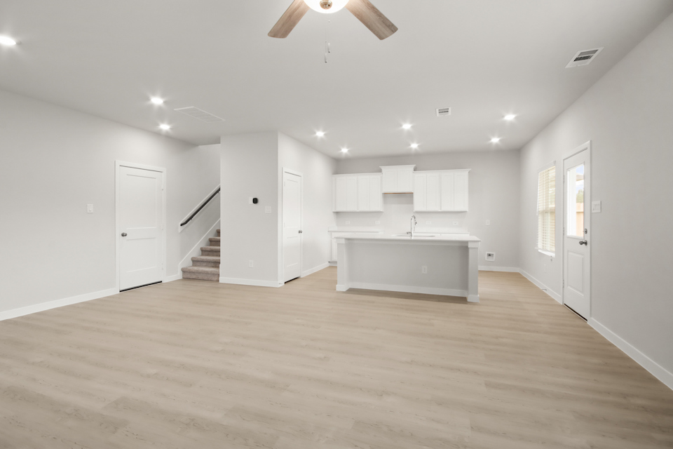 A large empty room with white cabinets.