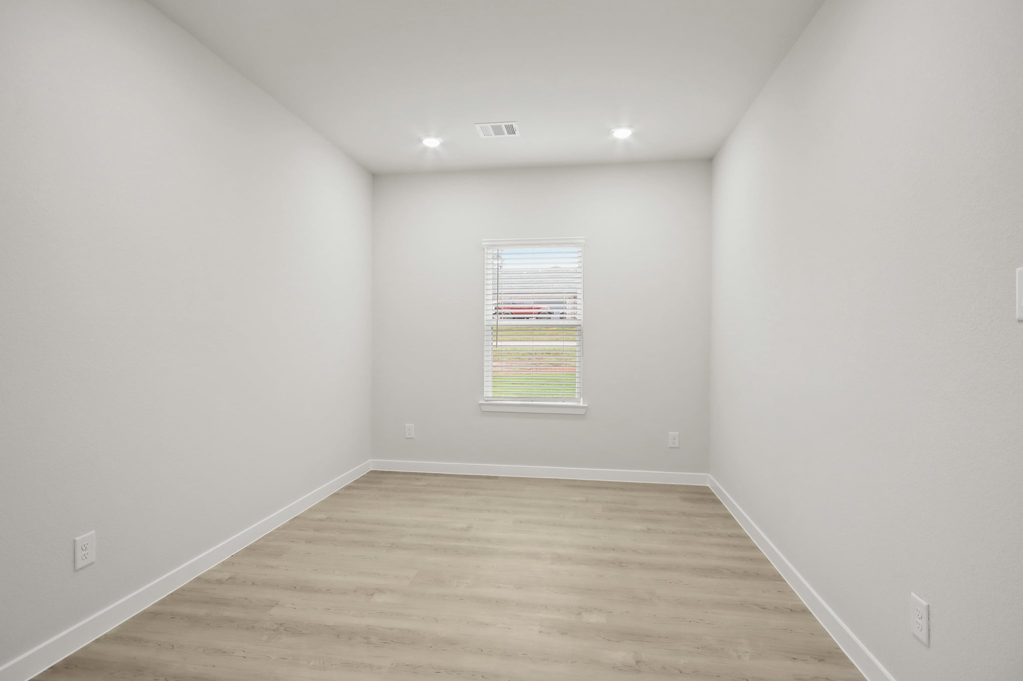 A room with a wood floor and a window.