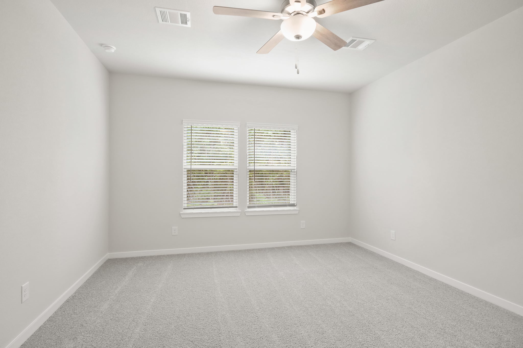 A room with a ceiling fan and a window.