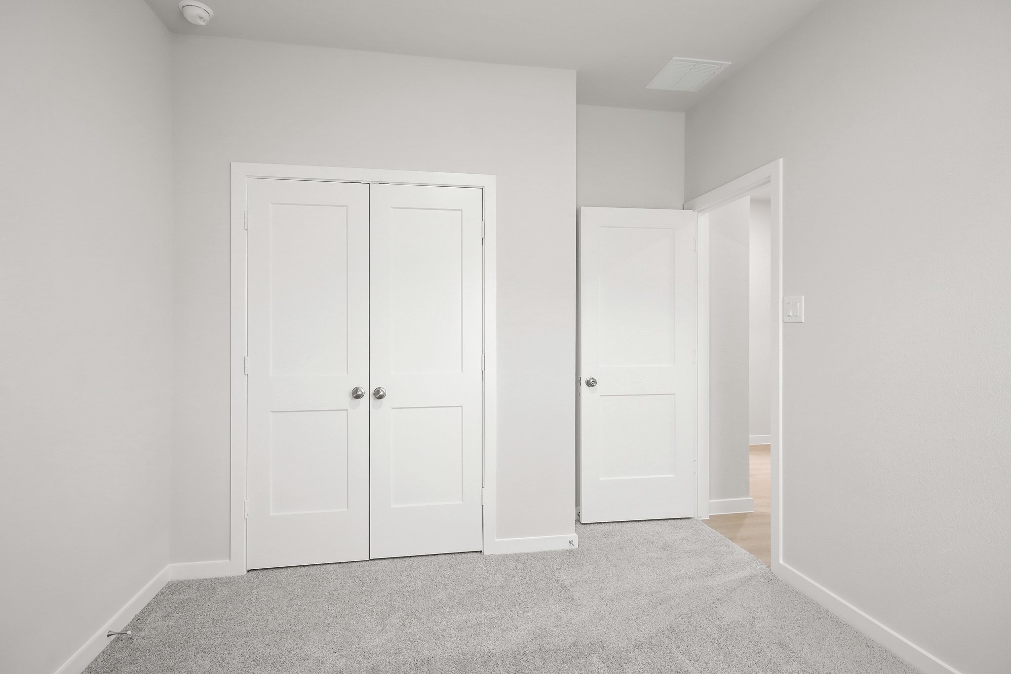 A hallway with white doors.
