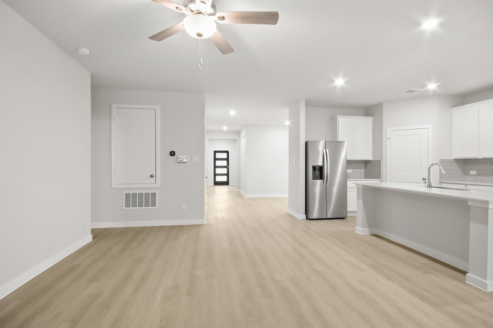 A kitchen with white cabinets.