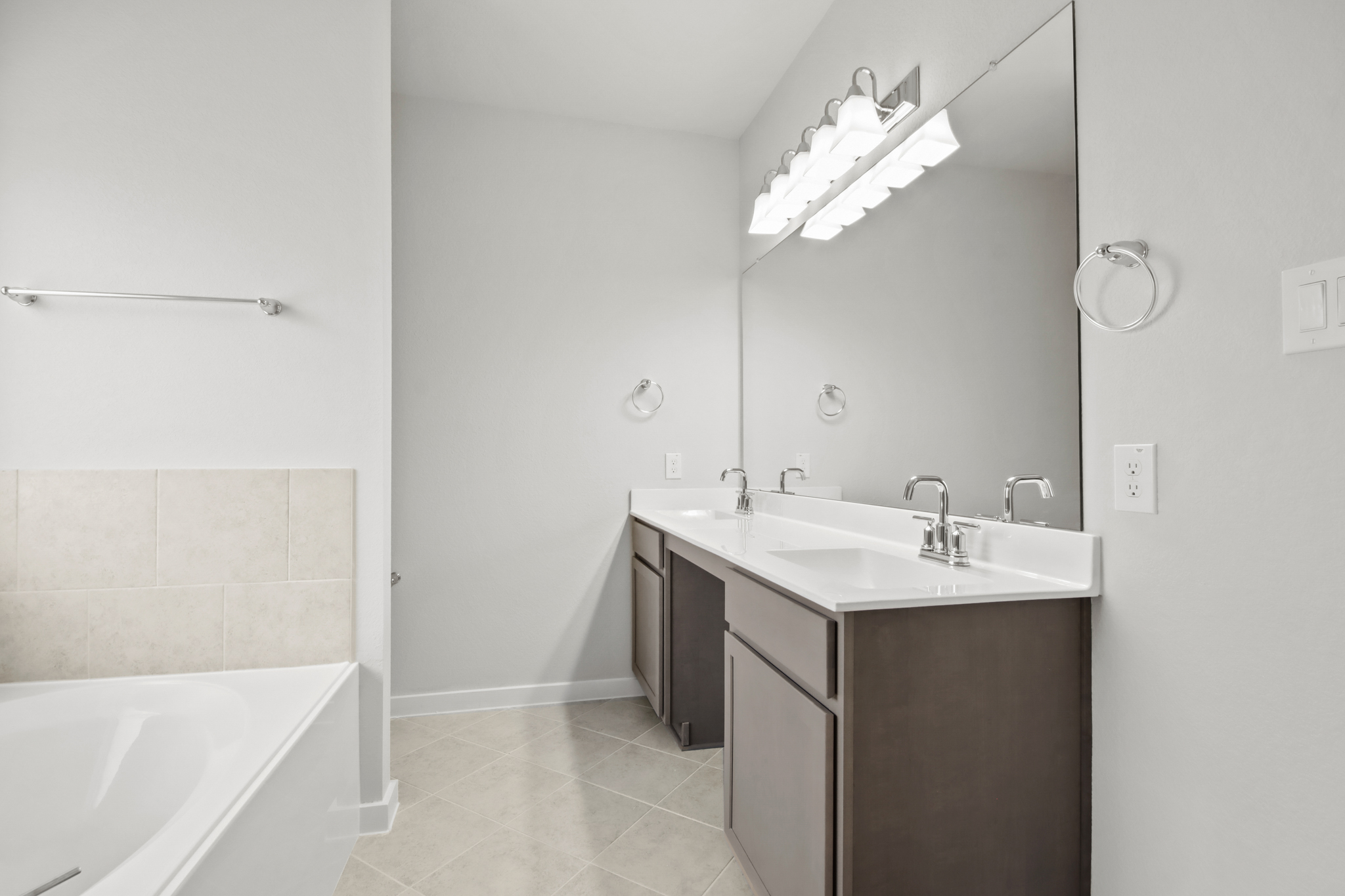 A bathroom with a tub sink and mirror.