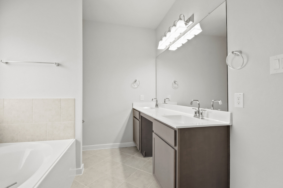 A bathroom with a tub sink and mirror.
