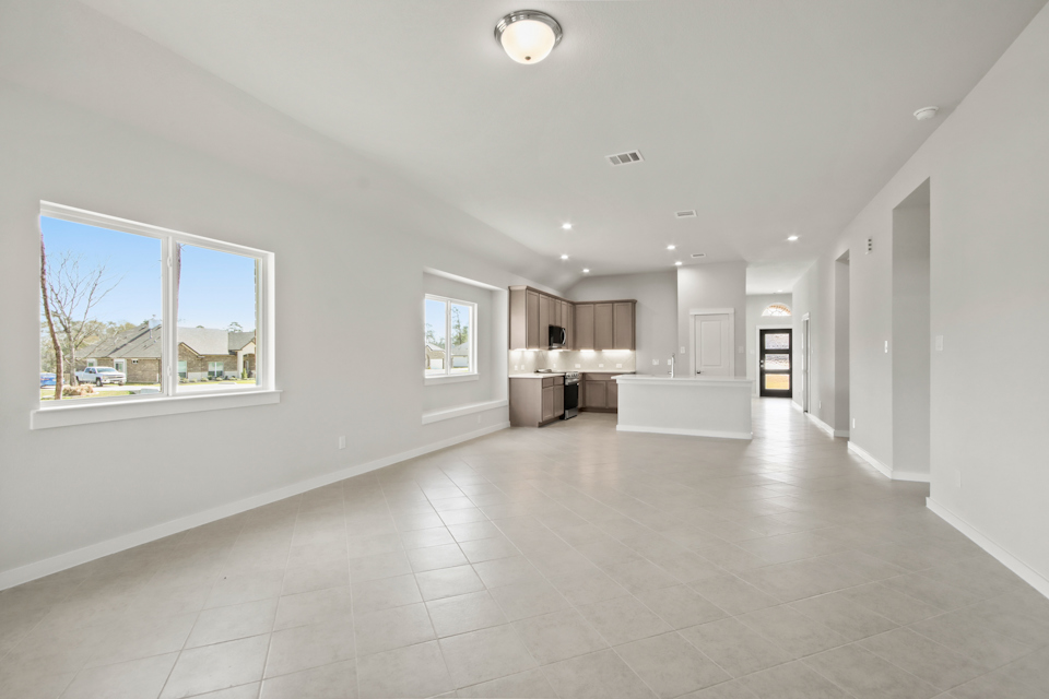 A large white room with a large window and a large white tile floor.