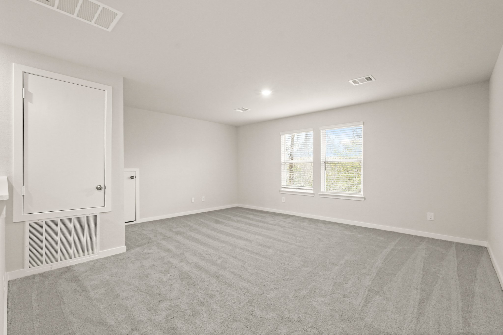 A room with a carpet and a window.