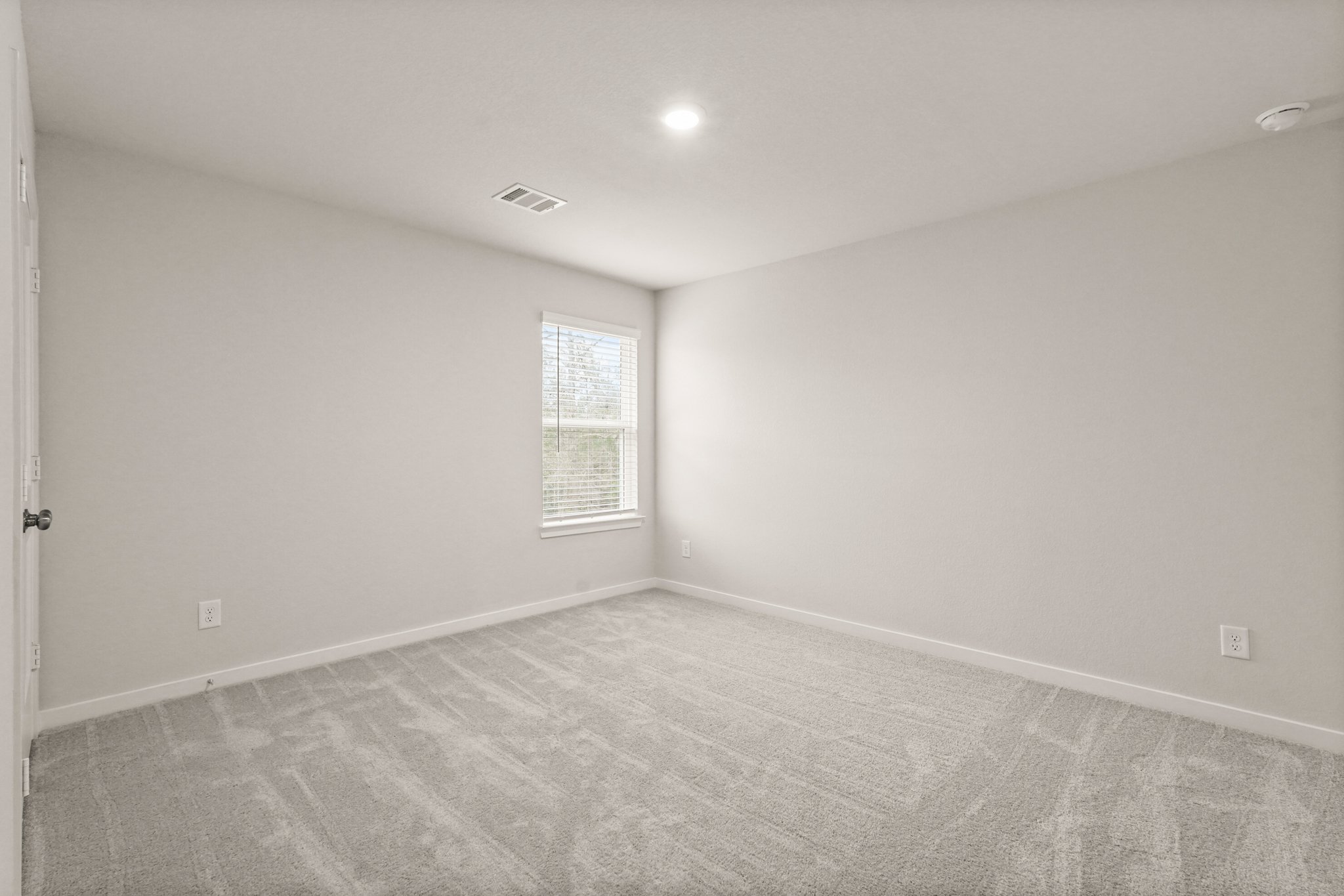 A room with a window and a carpet.