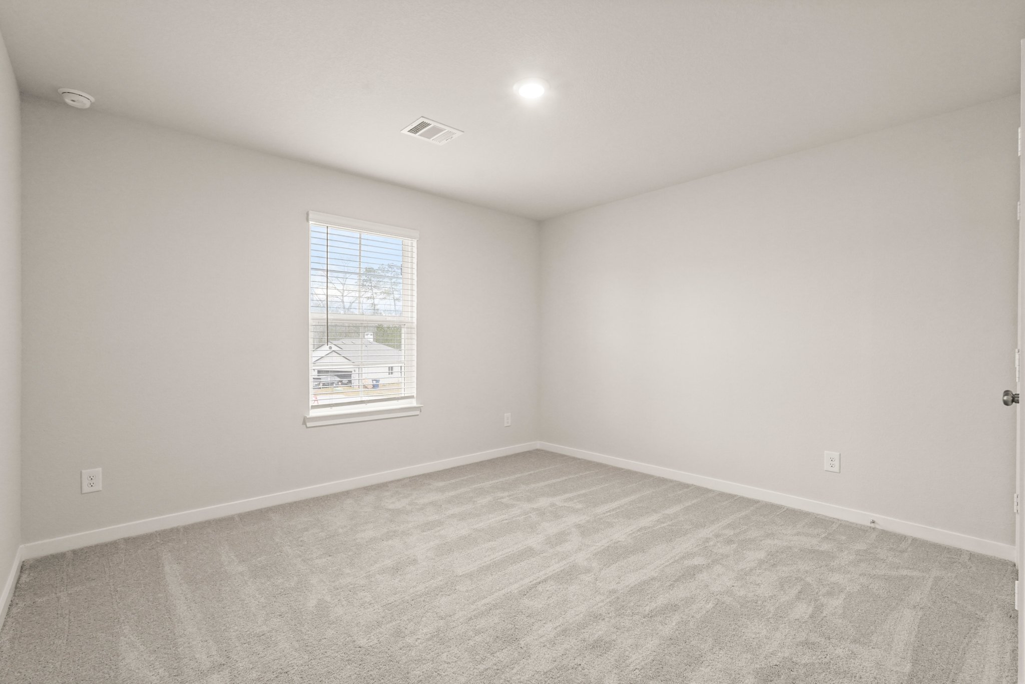 A room with a window and a carpet.