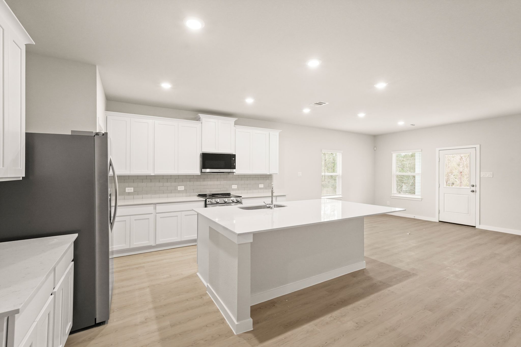 A kitchen with white cabinets.