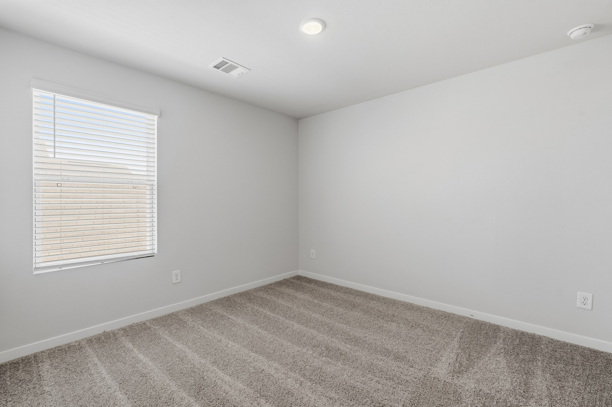 A room with a window and a carpet.