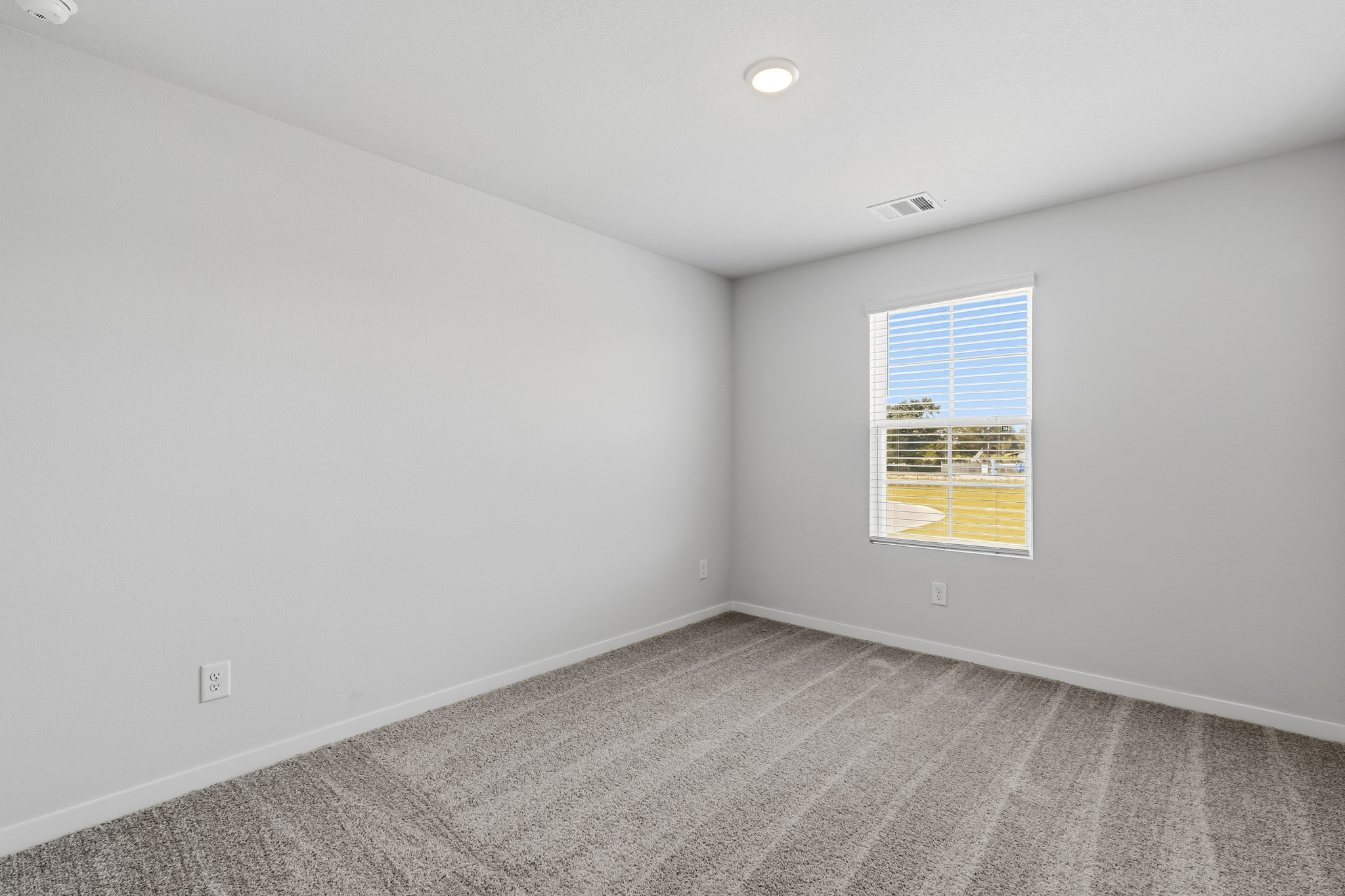 A room with a window and a carpet.