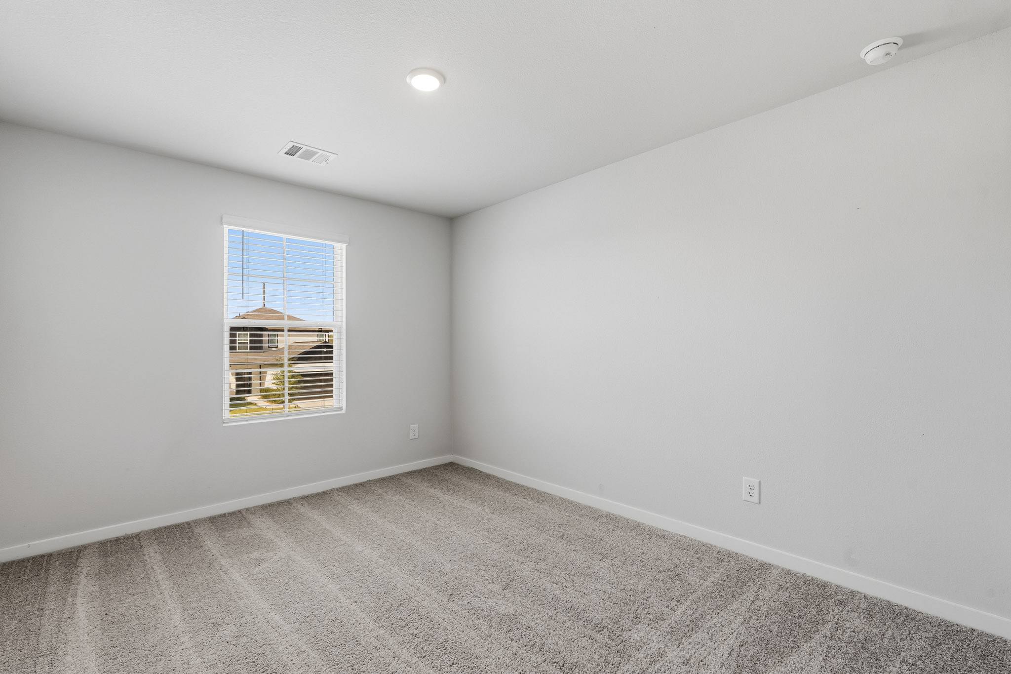 A room with a window and a carpet.