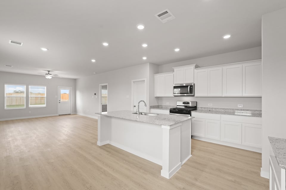 A kitchen with white cabinets.