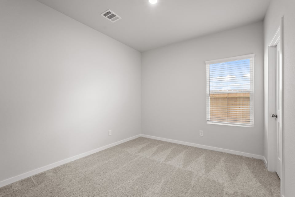 A room with a carpet and a window.