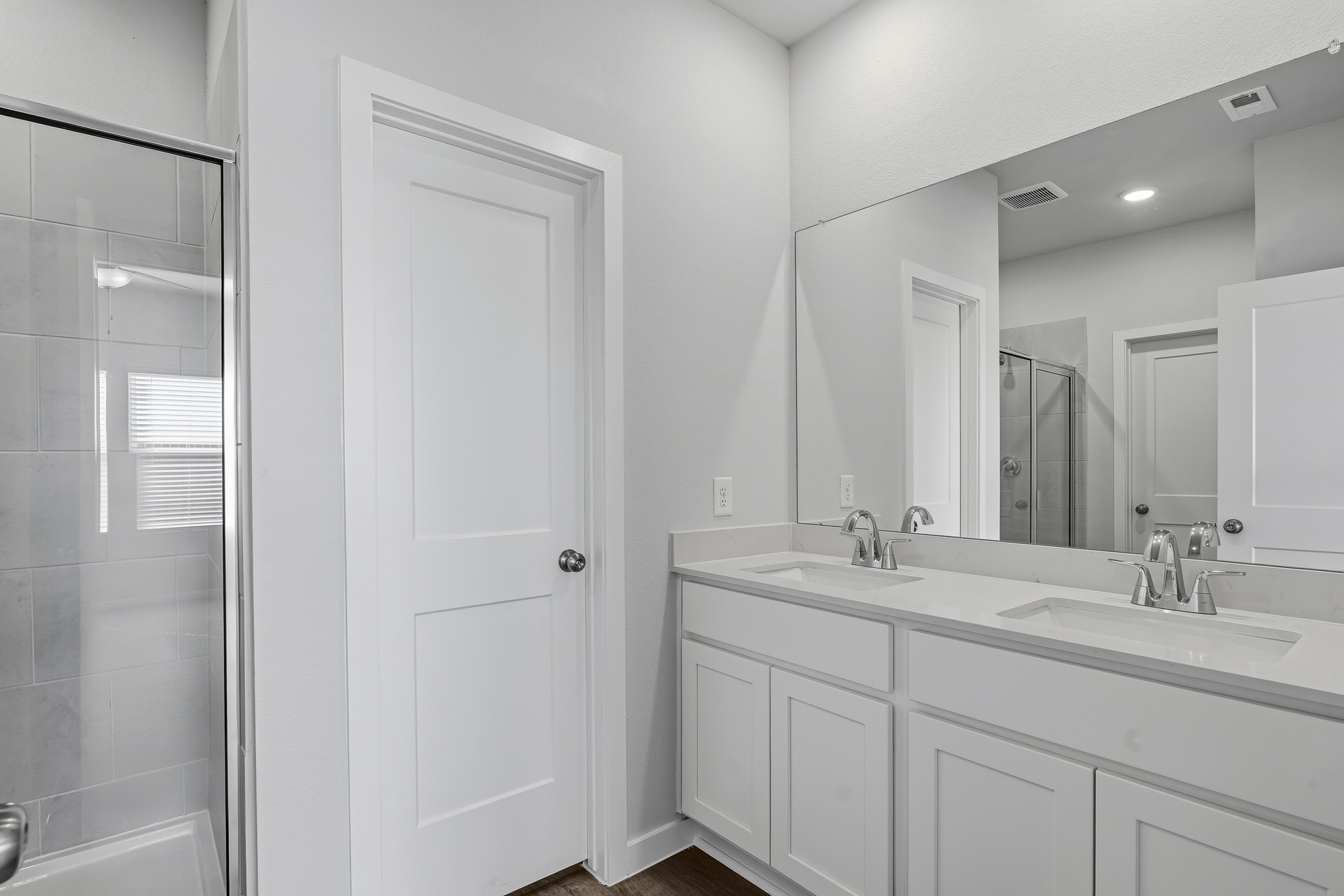 A bathroom with white cabinets.