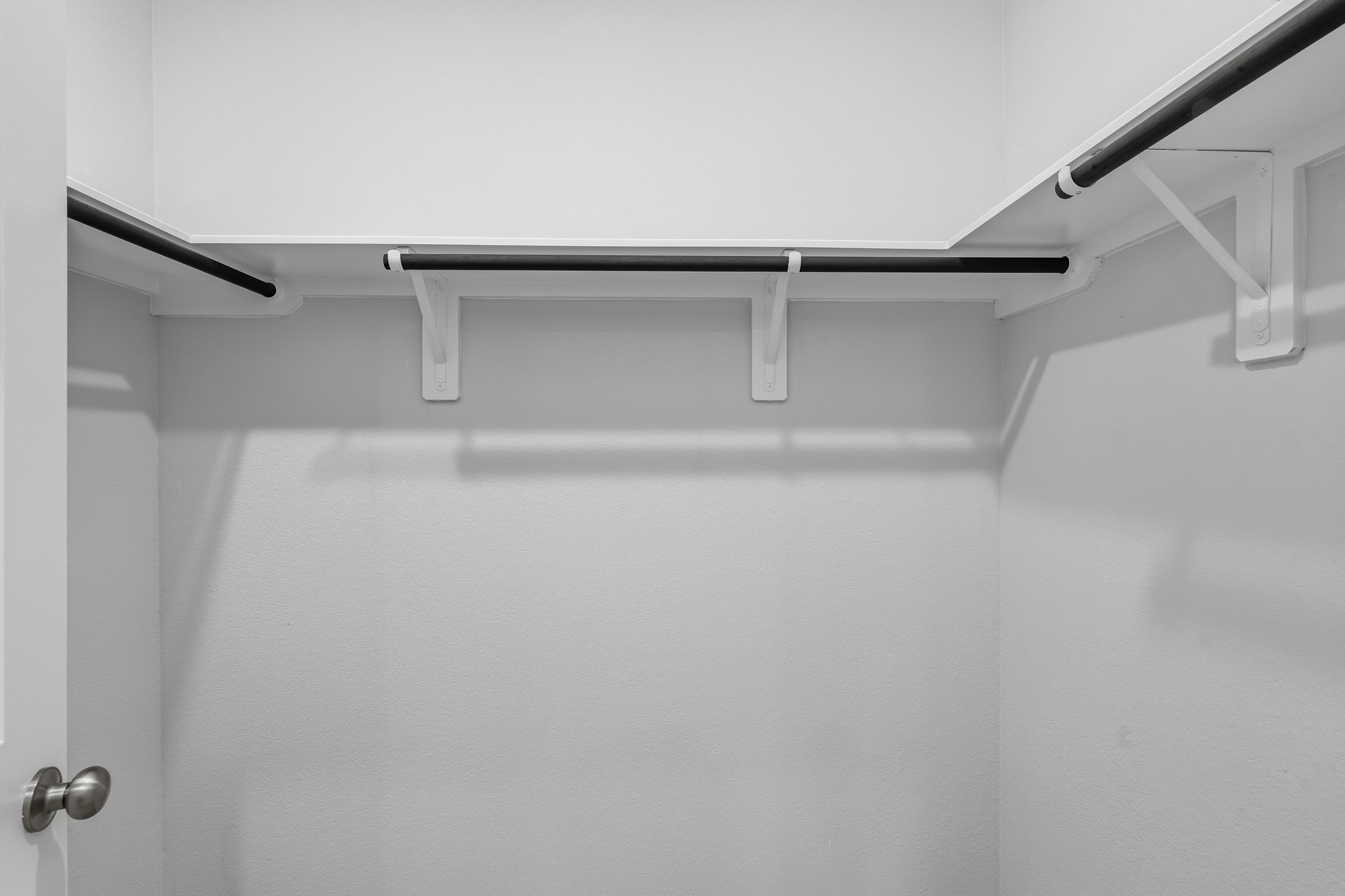 A white ceiling with a metal bar.