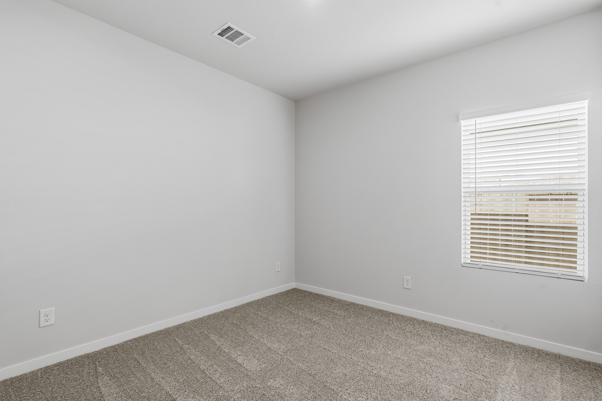 A room with a window and a carpet.