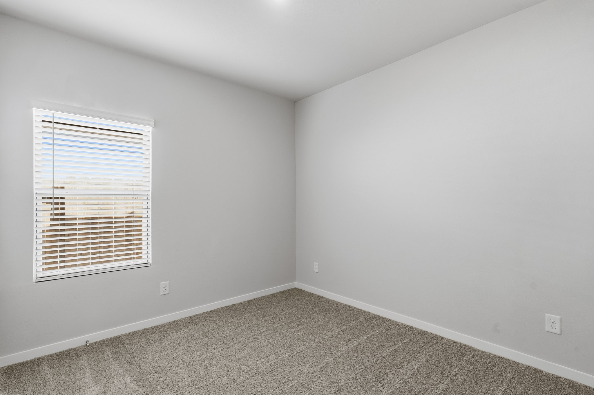 A room with a window and a carpet.
