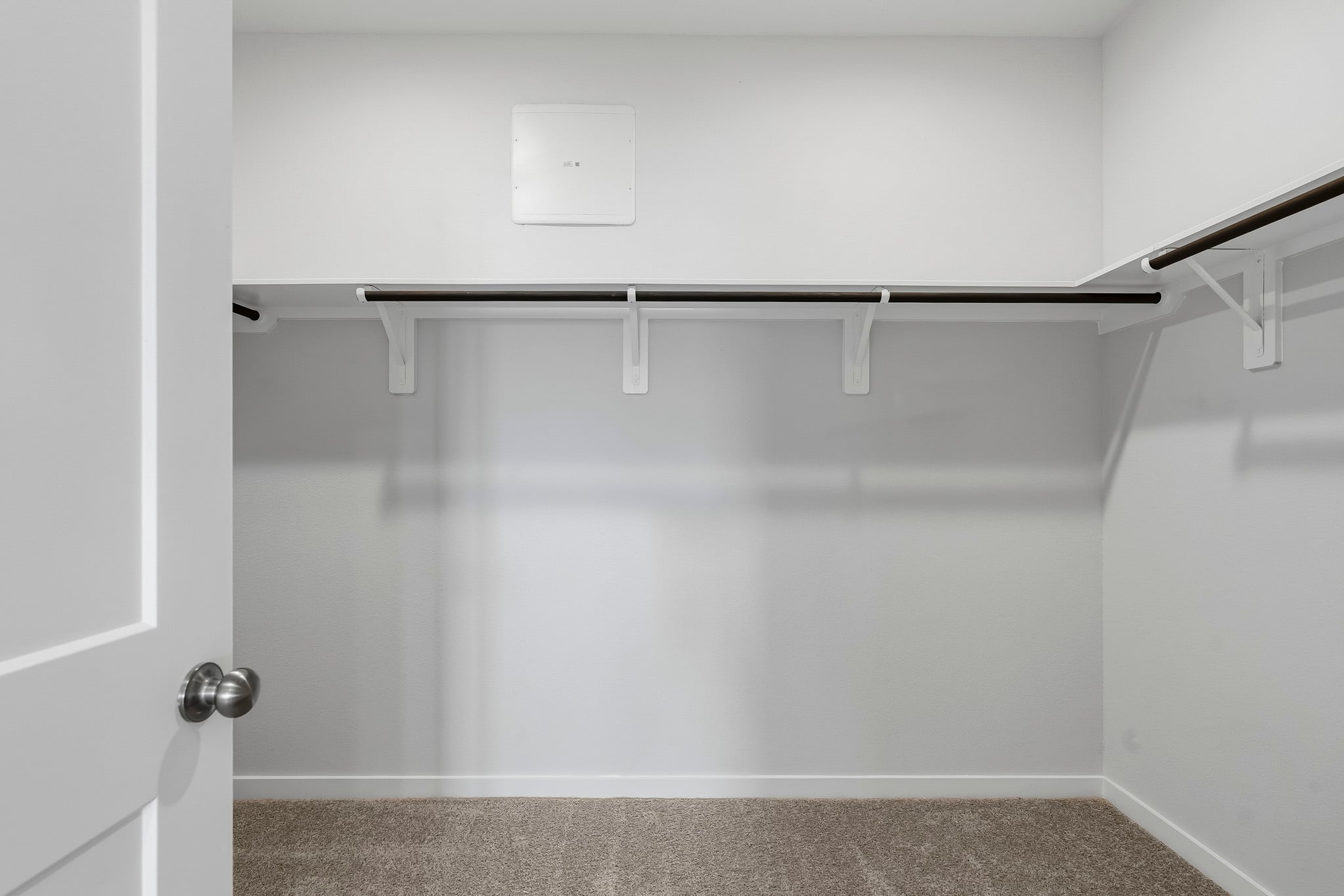 A white wall with a metal bar.