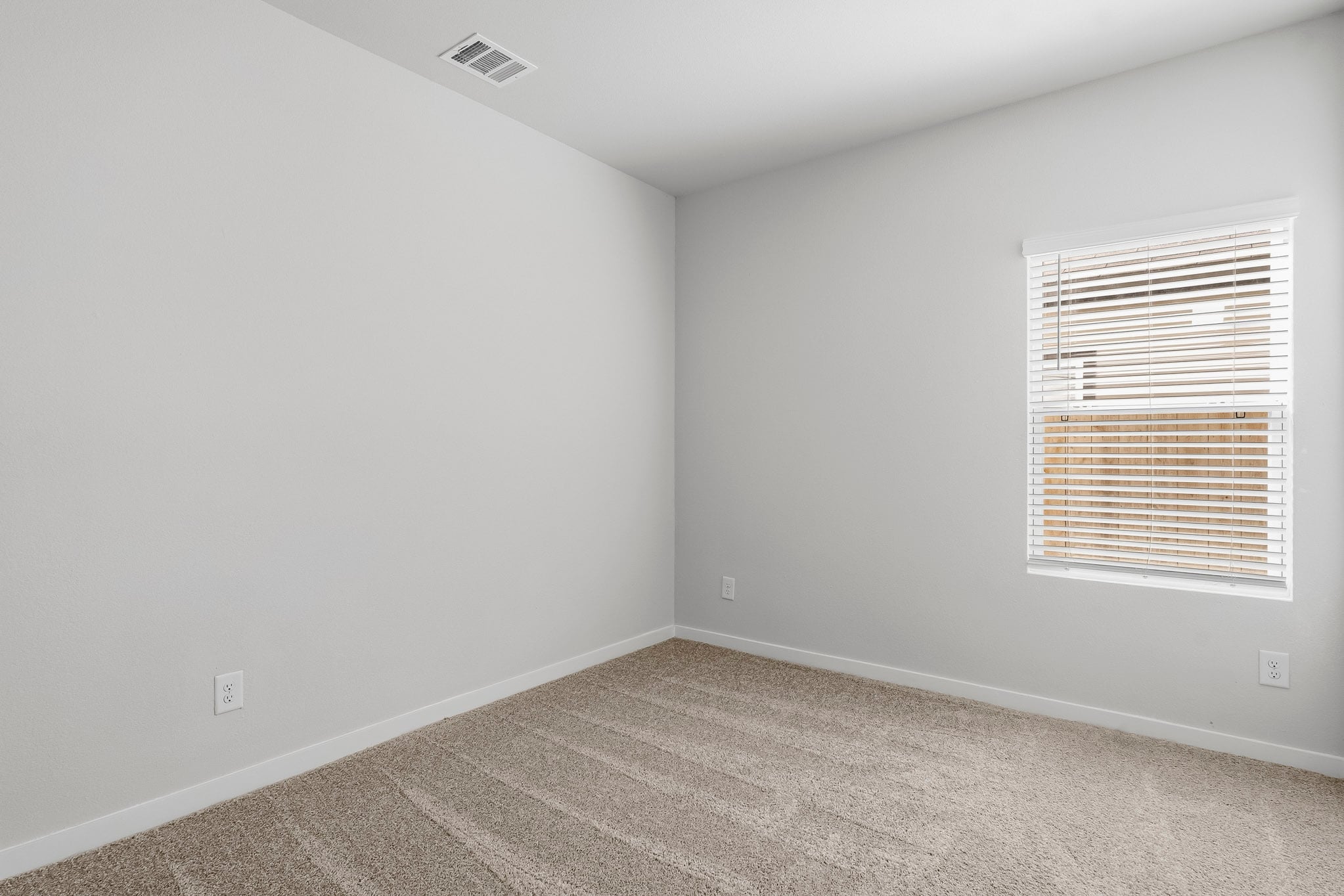 A room with a window and a carpet.