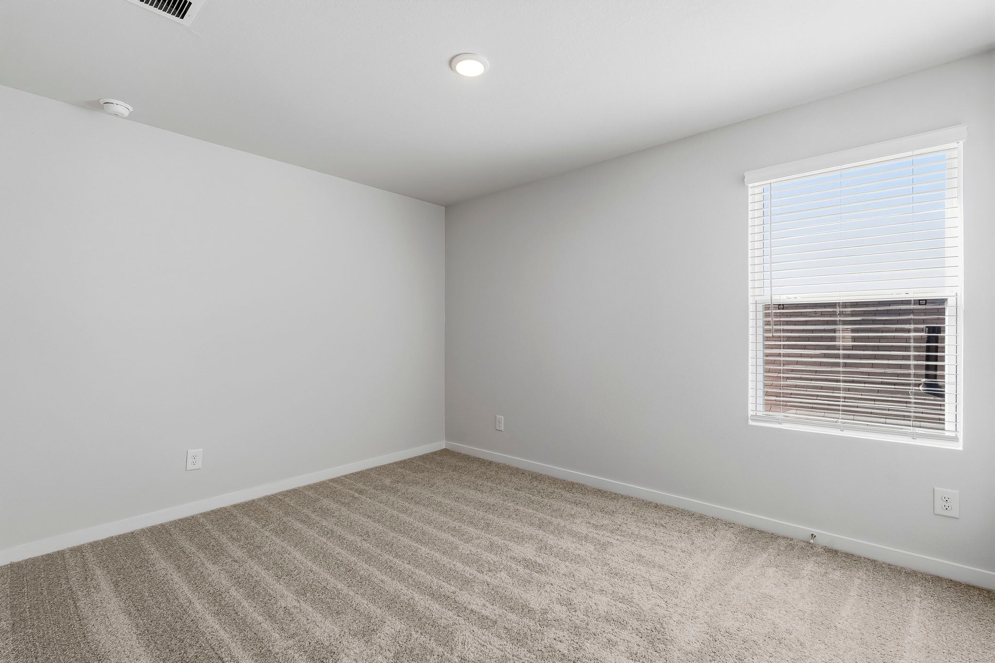 A room with a window and a carpet.