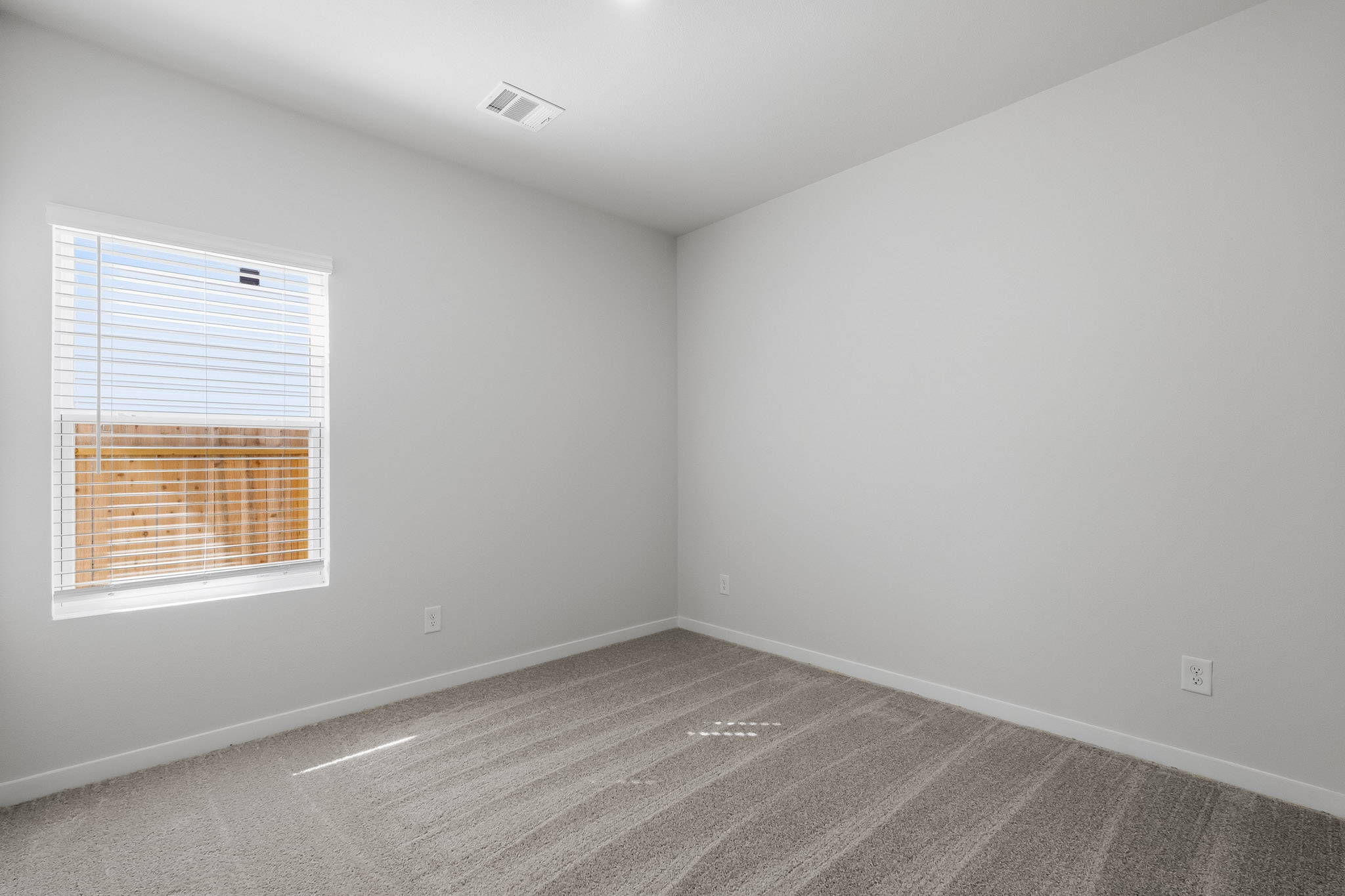 A room with a window and a carpet.
